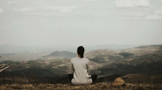 woman enjoying a beautiful view of mountains during a time of personal retreat